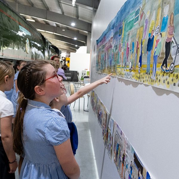 group of children pointing at artwork on a wall
