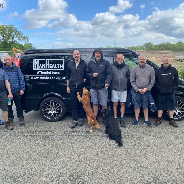group of men standing in front of a black van