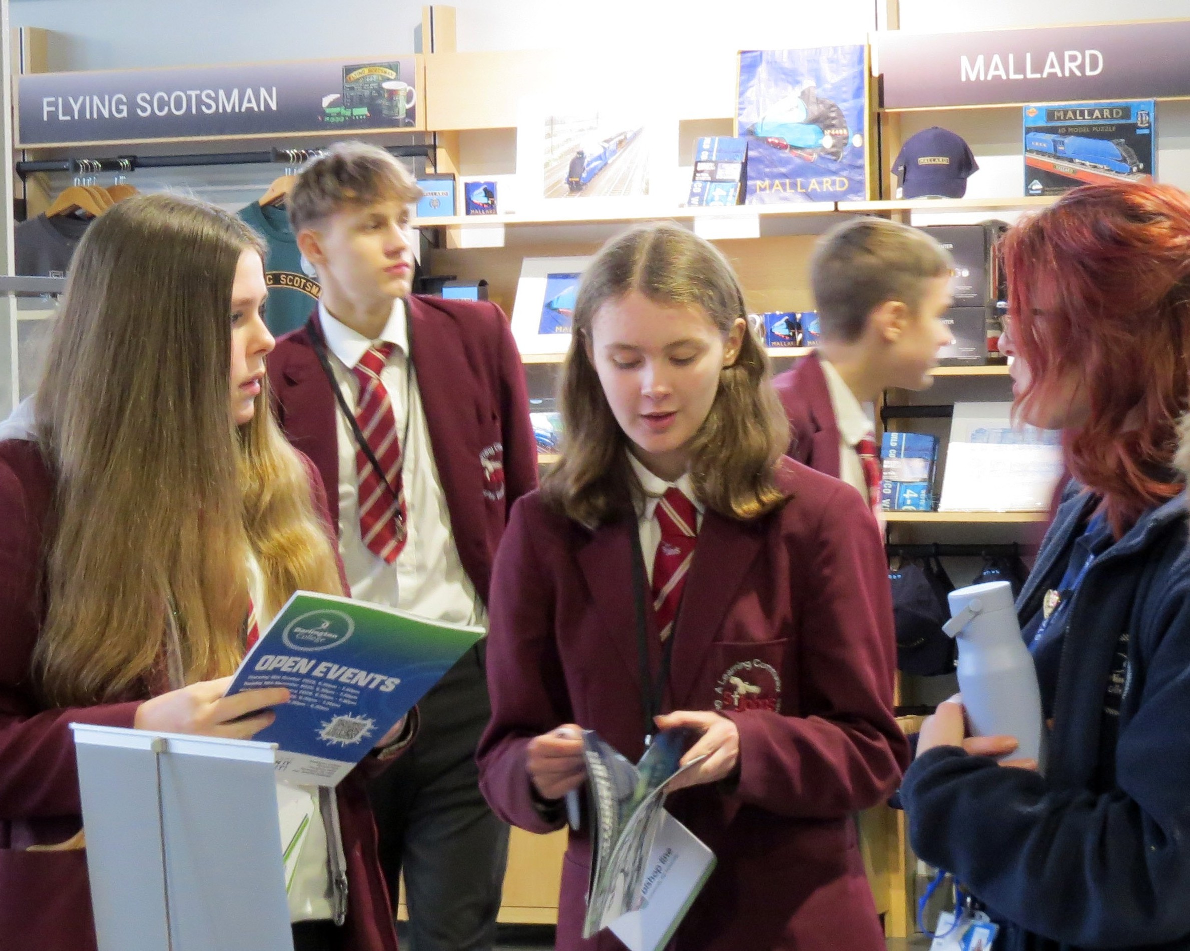 people standing in a museum holding brochures