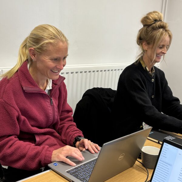 two adults working at laptops