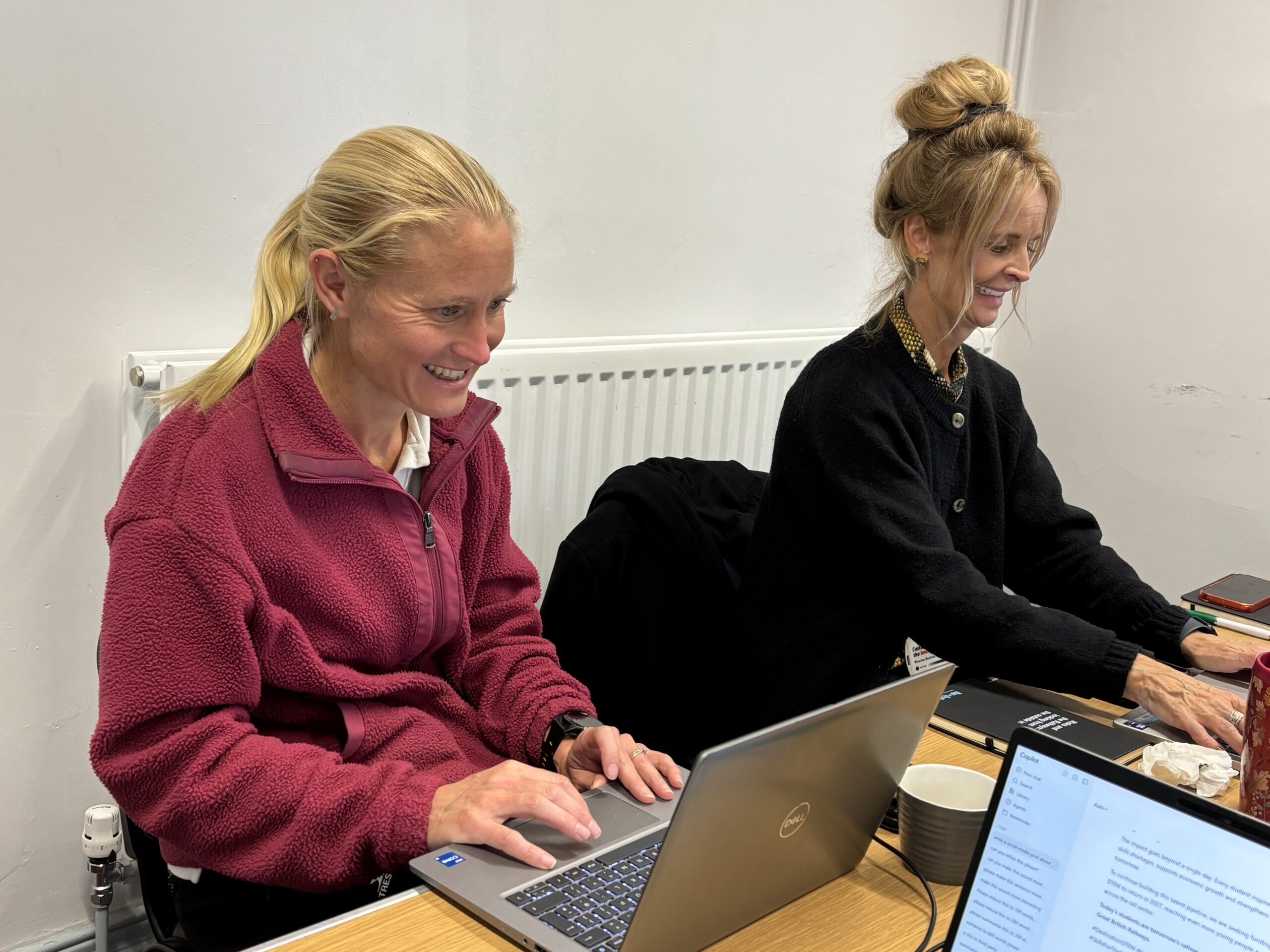 two adults working at laptops