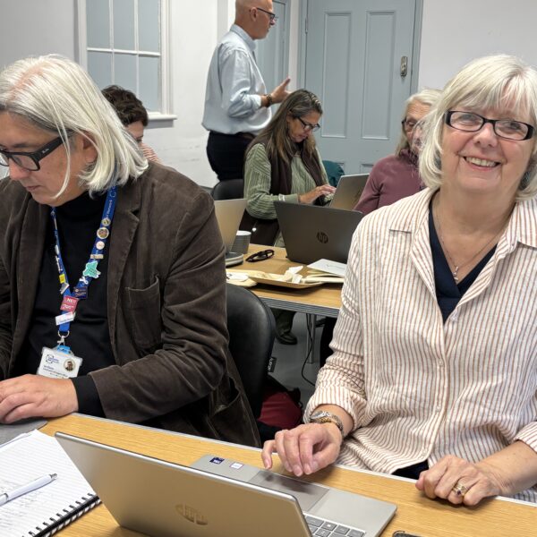 two adults working at laptops