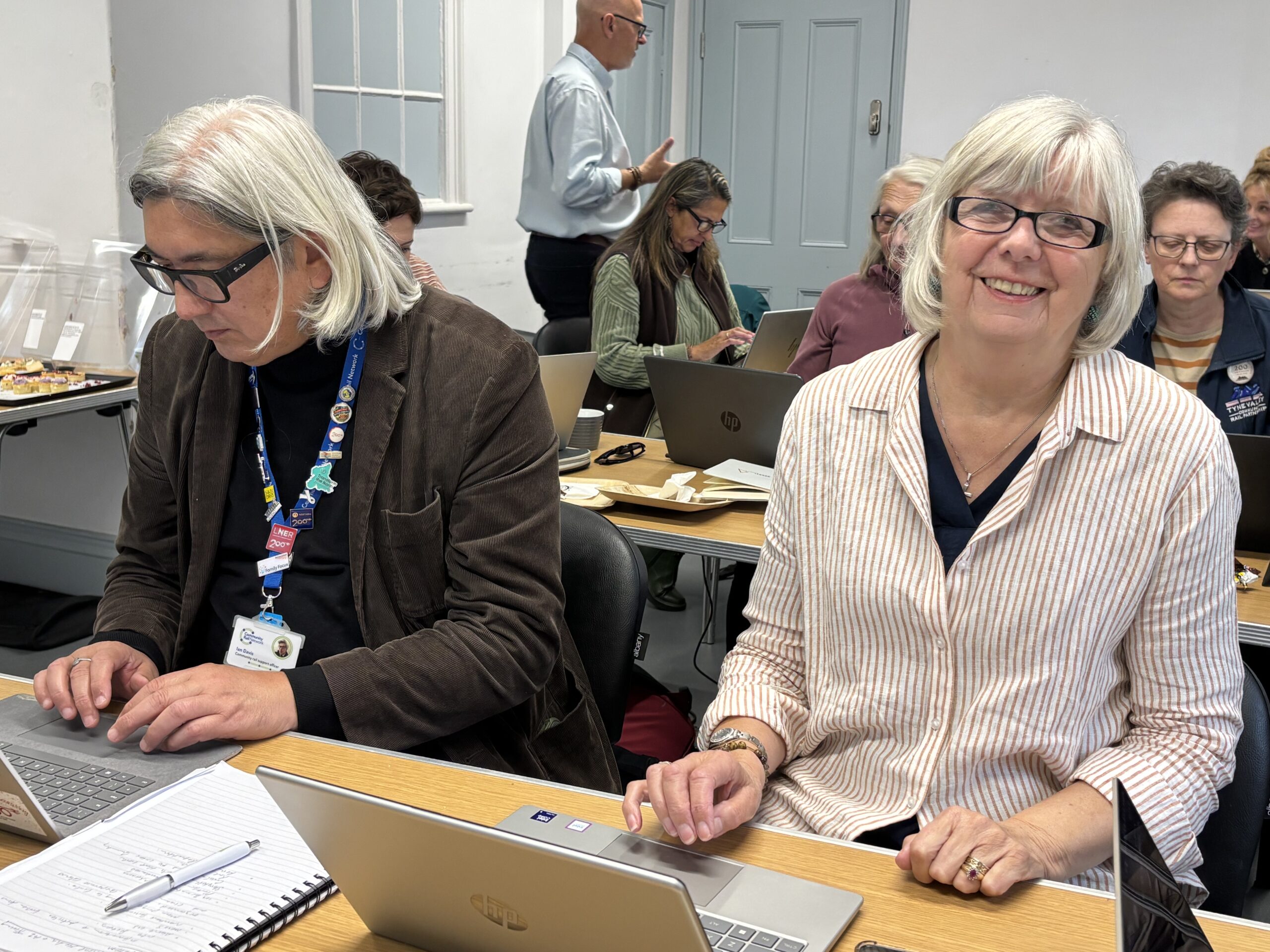 two adults working at laptops