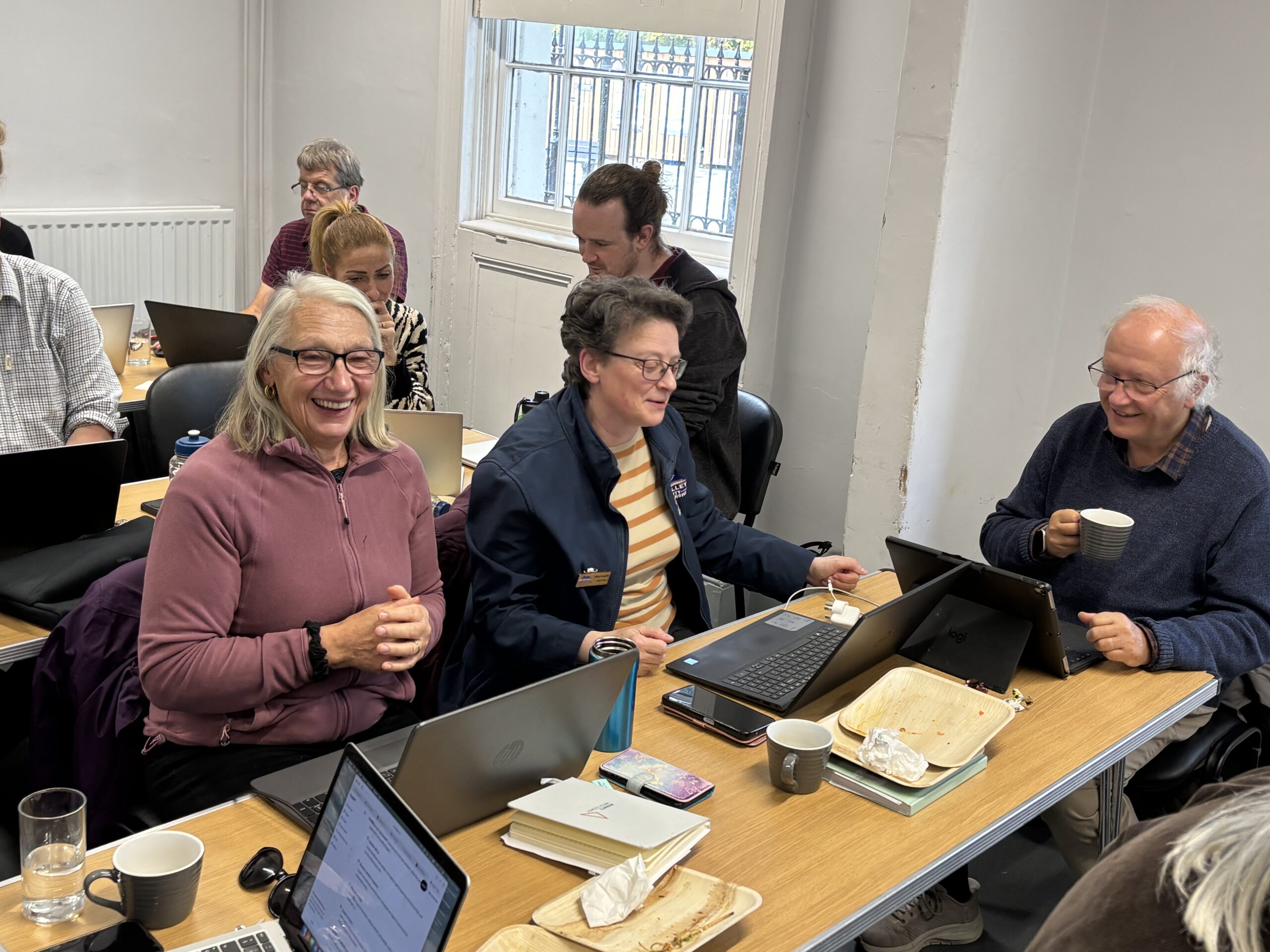 3 adults working at laptops